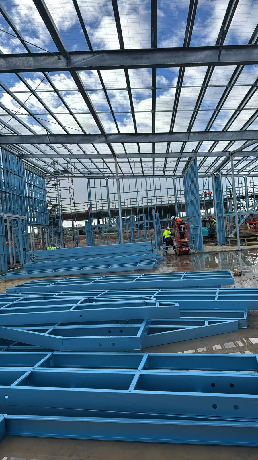 Prefabricated steel wall frame panels stacked inside a commercial building